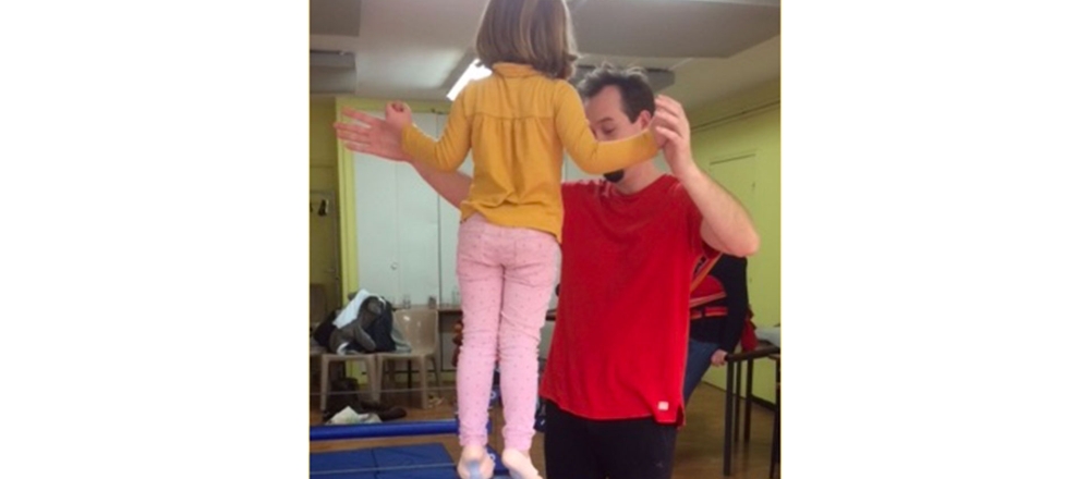 Animateur d'Histoire de fêtes aidant une petite fille à avoir la bonne posture comme au cirque